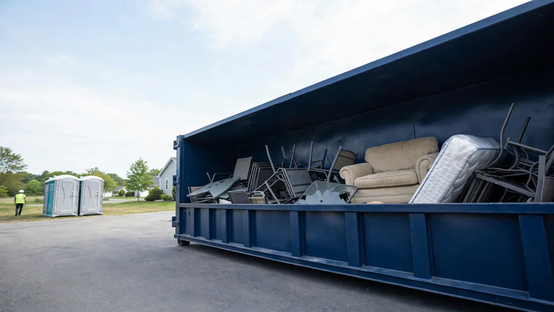Dumpster loaded with old furniture and household junk