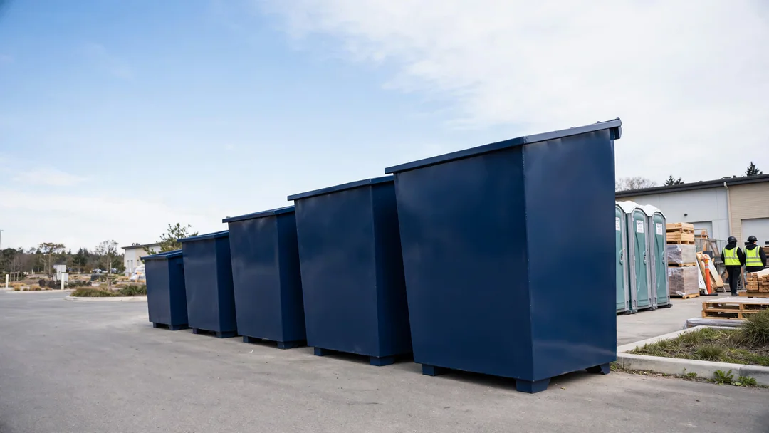 Row of roll-off dumpsters from small to large